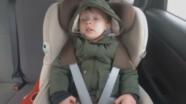 Arabanın arka koltuğunda uyuyan küçük bir çocuk var. Araba kötü bir yola giriyor. Bebekle seyahat et.