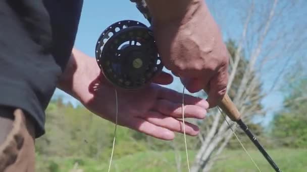 Homem pesca com mosca em um rio close-up — Vídeo de Stock