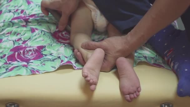 Close-up mam doen voet massage naar een pasgeboren baby jongen — Stockvideo