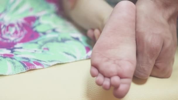Närbild mamma gör fotmassage till en nyfödd pojke — Stockvideo