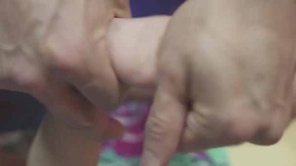 Мама крупным планом делает массаж ног новорожденному мальчику — стоковое видео