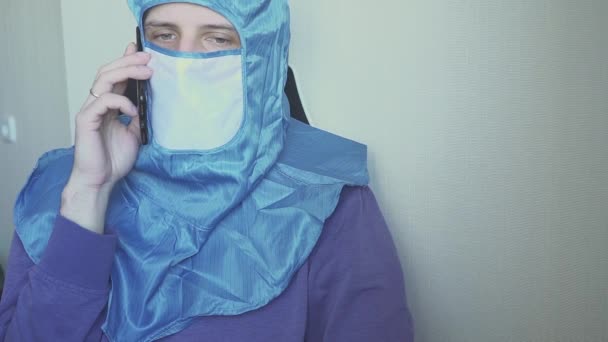 Ung man ringer med en medicinsk mask i ansiktet. En man i skyddsmask är skyddad från viruset.. — Stockvideo