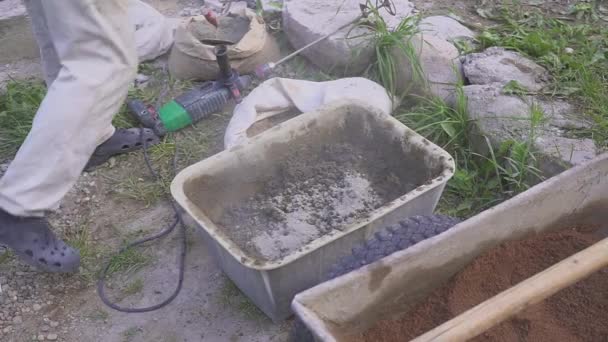 En arbetstagare förbereder en blandning av cement. Hinders med en borr. Närbild. — Stockvideo