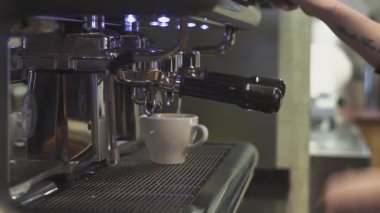 Profesyonel barmen kahve dükkanında cappuccino hazırlar.