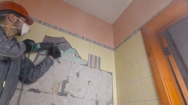 오래 된 타일을 착암기와 함께 철거 한다. 화장실이나 부엌에 있는 낡은 벽을 개축하는 모습 — 비디오
