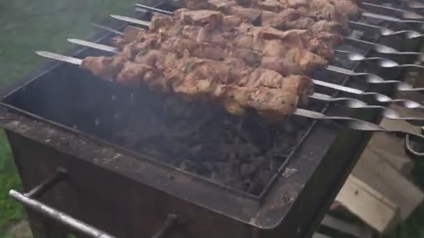 Ocio, comida, gente y concepto de vacaciones. Cocinar patatas fritas carne en un fuego en una fiesta callejera. cocinar carne en la parrilla barbacoa — Vídeos de Stock