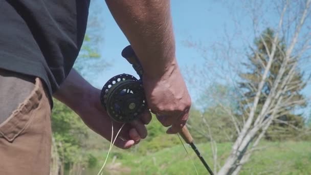 Человек летит на рыбалку в реке крупным планом — стоковое видео