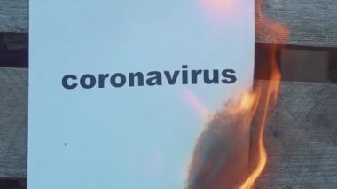 Üzerinde siyah kelime CORONAVIRUS olan yavaş çekim yakma kağıdı. Dünya Savaşı konsepti. yanan kelimeler.