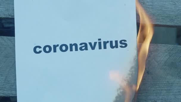 검은 단어 CORONAVIRus 와 함께 천천히 움직이는 종이. 세계 대전 컨셉이야. 불타는 말들. — 비디오