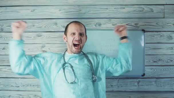 Ten lek jest skuteczny. koronawirus COVID-19 lek. szczęśliwy mężczyzna biały lekarz z jasna broda taniec w jego medyczny biuro — Wideo stockowe
