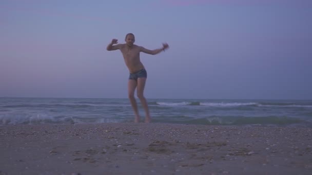 Glücklicher Mann tanzt am Strand Am Sonnenuntergang — Stockvideo