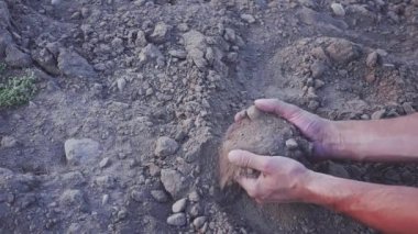 Yavaş çekim videosunda insanların elleri toprak tozu tutuyor. Kuraklık, yağmursuz topraklar