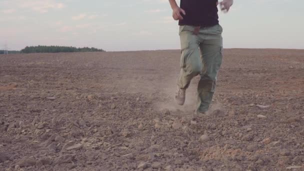 O homem corre para o campo seco. CONCEITO SOBRE O TEMA DO PROJECTO — Vídeo de Stock