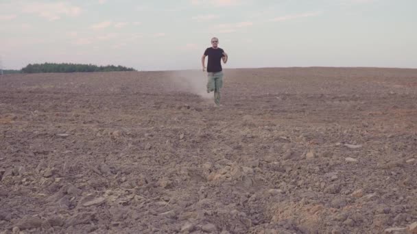 O homem corre para o campo seco. CONCEITO SOBRE O TEMA DO PROJECTO — Vídeo de Stock