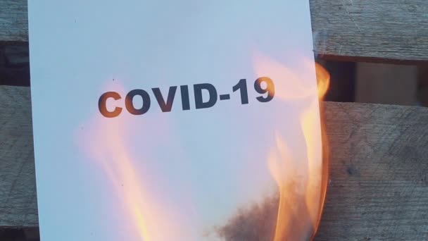 COVID-19という黒い文字の紙は、第二次世界大戦の概念を燃やしています。スローモーション — ストック動画