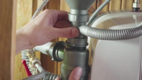 Man installing a drain for a kitchen sink — Stock Video