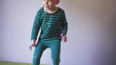 Yatak odasında yatağa atlayan mutlu çocuk. Çocukluk kavramı.