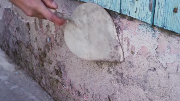 Close up χέρι με μπρούτζινο σύρμα βούρτσα τρίψιμο βρωμιά λεκέ στο λευκό τσιμέντο έξω από τον τοίχο του σπιτιού, τοίχους για την ανακαίνιση — Αρχείο Βίντεο