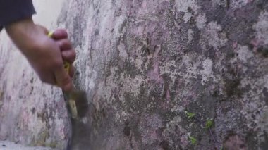 Elinizi pirinç tel fırçayla kapatın. Beyaz çimento üzerindeki toprak lekesini temizleyin. Duvarları yenilemek için.