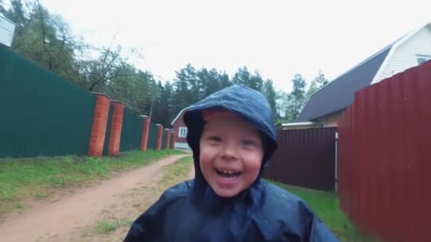 Glada små barn som har kul springandes i regnet — Stockvideo