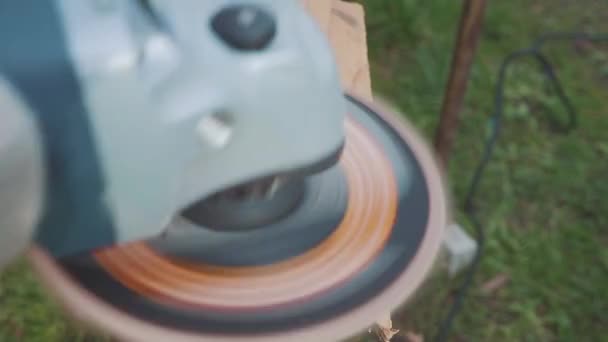 The man is working with angle grinder for the grinder of the wooden board. — Stock Video