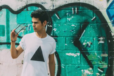 Graffiti duvar önünde çekici modern genç Brezilyalı adam