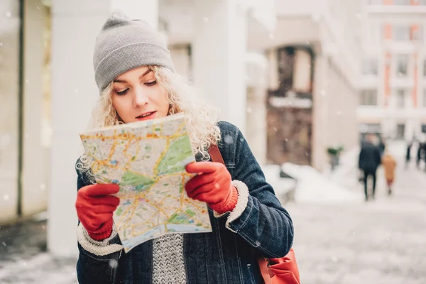 Кудрявая блондинка с картой, зима — стоковое фото