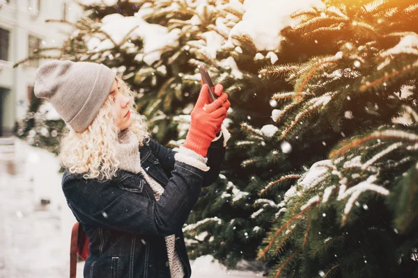 Rubia chica rizada haciendo foto en el teléfono inteligente, invierno —  Fotos de Stock