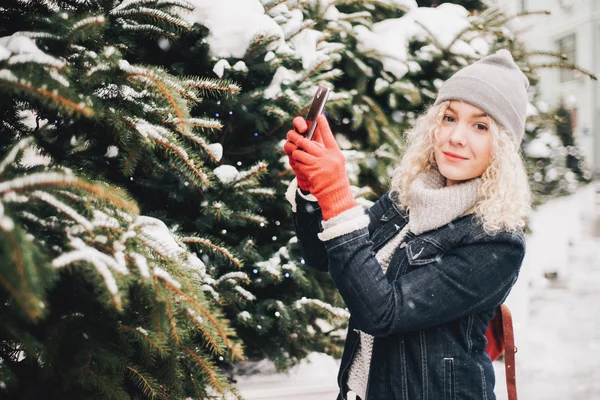 Rubia chica rizada haciendo foto en el teléfono inteligente, invierno —  Fotos de Stock