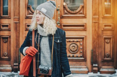 Genç sarışın kıvırcık kız retro film kamera ile kış