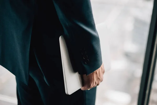 Рука человека в официальном костюме с ноутбуком — стоковое фото