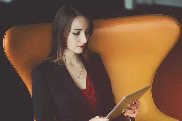 Молодая деловая женщина в красном платье и пиджаке с планшетом — стоковое фото