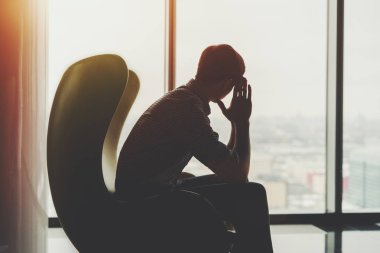 Sihluette pencere yakınındaki düşünceli işadamı