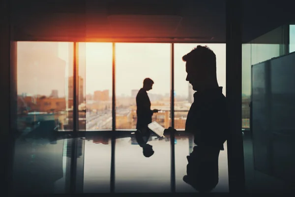 Silhouette of two businessmen in office interior — Stock Photo, Image