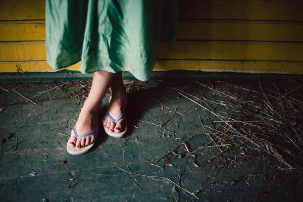 Kaki perempuan dalam sandal pada latar belakang kayu — Stok Foto