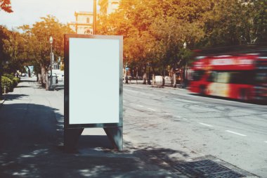 Kırmızı turistik otobüs yakınındaki boş billboard