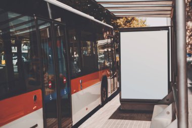 Beyaz kırmızı otobüs yakınındaki billboard