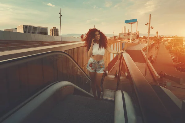 Girl talking on phone on the escalator — Stock Photo, Image