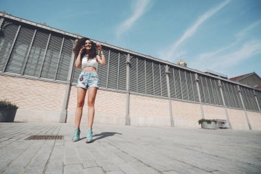 Gülümseyen kıvırcık güzel esmer kız sokakta