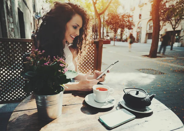 Rizado sonriente hermosa chica usando digital tablet en café — Foto de Stock