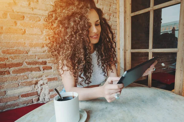 Curly brunette girl with digital tablet in cafe — Stock Photo, Image