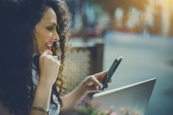 Curly brunette girl in cafe with smartphone and laptop — Stock Photo, Image