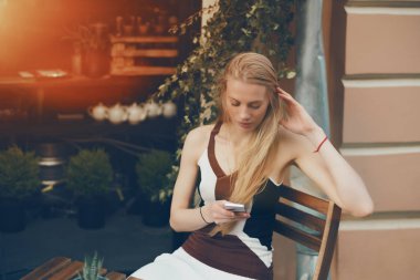 Kafede akıllı telefon kullanan sarışın dalgın güzel kadın