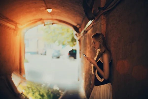 Mujer rubia con smartphone en túnel — Foto de Stock