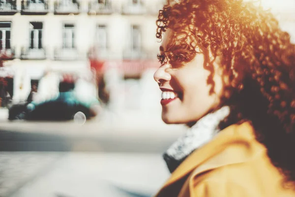 Smiling curly brazilian girl in yellow coat — Stock Photo, Image