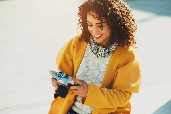 Adult curly brazilian sminling woman with retro camera — Stock Photo, Image