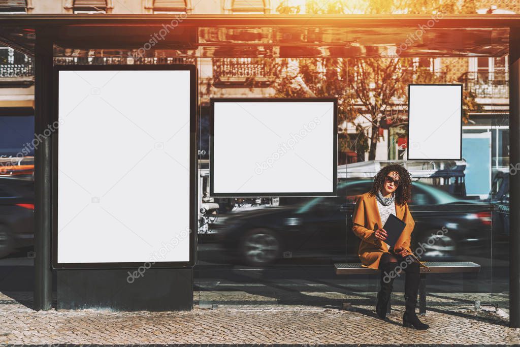 Curly woman iside of city bus stop