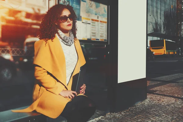 Beautiful curly lady with digital tablet waiting bus — Stock Photo, Image