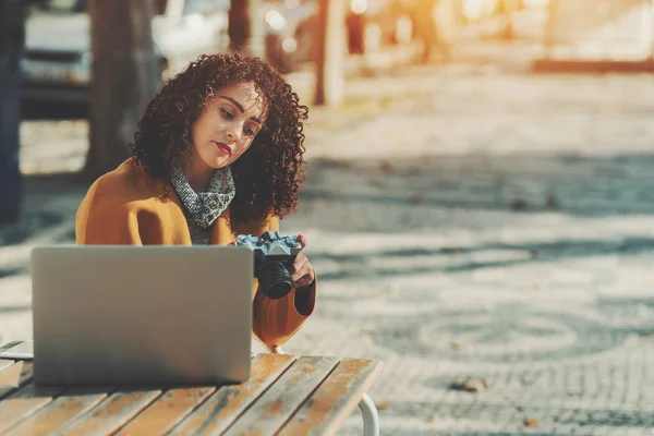 Woman in street cafe with vintage camera and laptop — Stock Photo, Image
