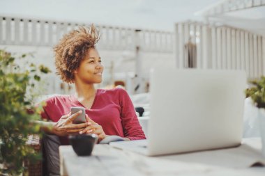 Kafede dizüstü bilgisayar ile siyah kıvırcık kız